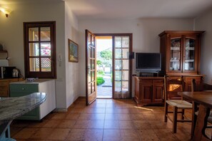 Eine Küche mit Essbereich, Fernseher und Schrank.