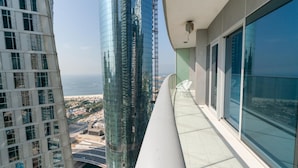 Ein Hochhaus mit einem Balkon, der auf eine Stadtlandschaft und ein Gewässer blickt.