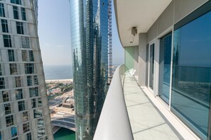 Ein Hochhaus mit einem Balkon, der auf eine Stadtlandschaft und ein Gewässer blickt.