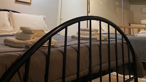 Une chambre à coucher avec un lit, un miroir et un plafond orné de panneaux décoratifs.