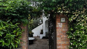 A brick gate with a number 19 sign, leading to a paved path and a white building. - Cactus Cottage With pool and a stone's throw from the famous Blue Grotto! (Anacapri)