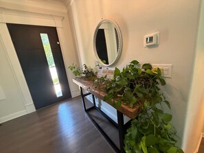 A hallway with a wooden bench, a mirror, and a potted plant. - Game Room Luxury Home @ Battery Chef Kitchen Deck (Marietta)