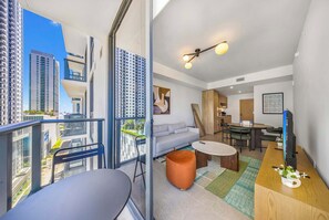 A modern apartment with a balcony, a sofa, a dining area, and a TV. - Miami Worldcenter 1BR | Gym & City Views (Miami)