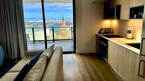 Eine moderne Wohnung mit Balkon, Küche und Blick auf eine Stadtlandschaft.