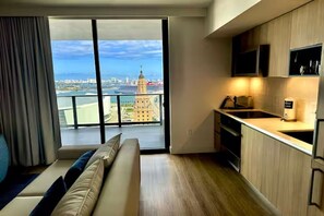 Eine moderne Wohnung mit Balkon, Küche und Blick auf eine Stadtlandschaft.