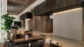 Eine moderne Lobby mit einer Couch, einem Couchtisch und Topfpflanzen.