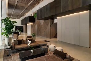 Eine moderne Lobby mit einer Couch, einem Couchtisch und Topfpflanzen.
