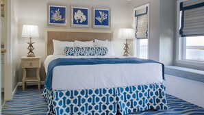 A bedroom with a bed, two bedside tables, a ceiling fan, and three framed wall art pieces. - BLOCK CW Ocean Ridge 1br (Edisto Island)