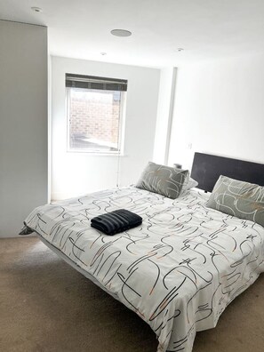 Ein Schlafzimmer mit Bett, Fenster und Tür.