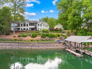 A large house with a dock and a small boat.