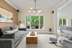 A modern living room with a grey sofa, a wooden coffee table, and a grey armchair.