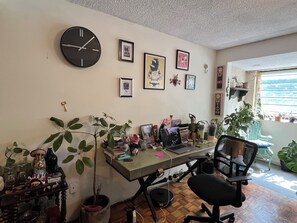 A room with a desk, chair, wall clock, framed pictures, and various plants. - Authentic urban jungle in Coyoacán, quiet and well-connected neighborhood (Ciudad de México)