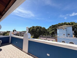 A balcony with a patterned floor, a blue wall, and a white balustrade. - Imperialis Boutique Hotel (Canavieiras)