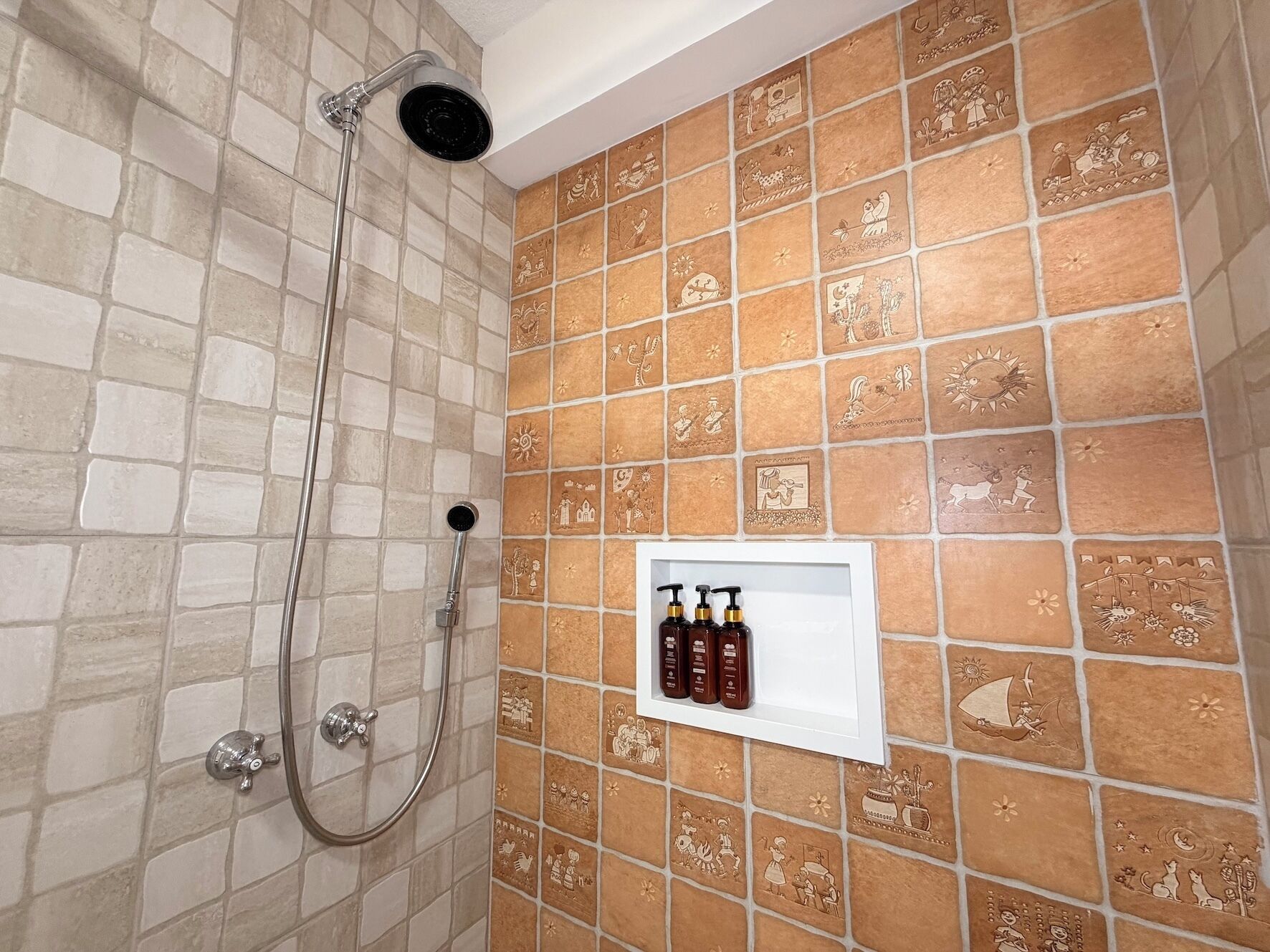 A shower area with a handheld showerhead and a wall-mounted shower head.