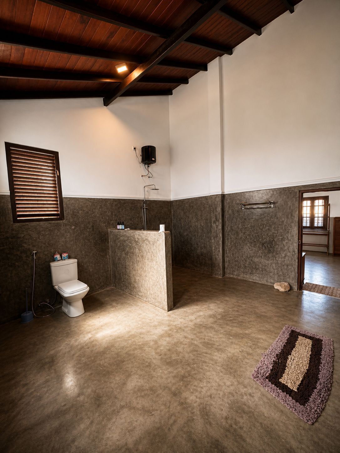 A bathroom with a toilet, shower, and a towel rack.
