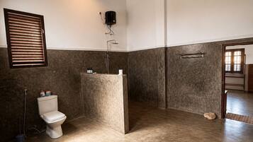 A bathroom with a toilet, shower, and a towel rack.