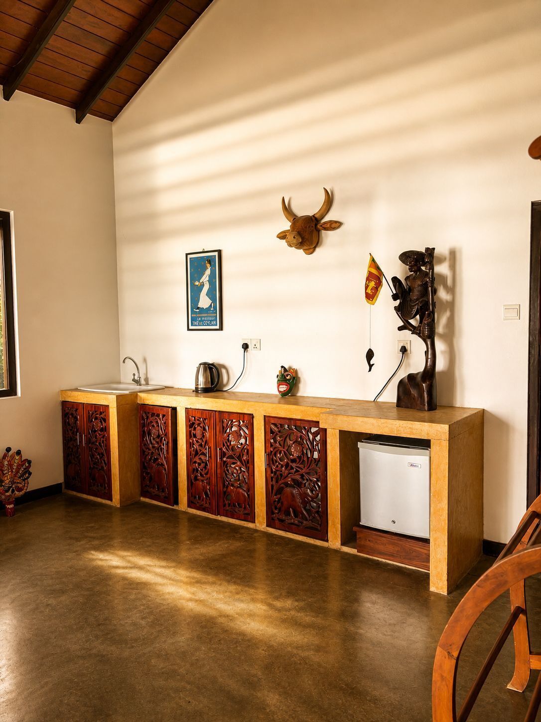 A kitchen with a wooden countertop, a sink, a coffee maker, and a decorative cow head.
