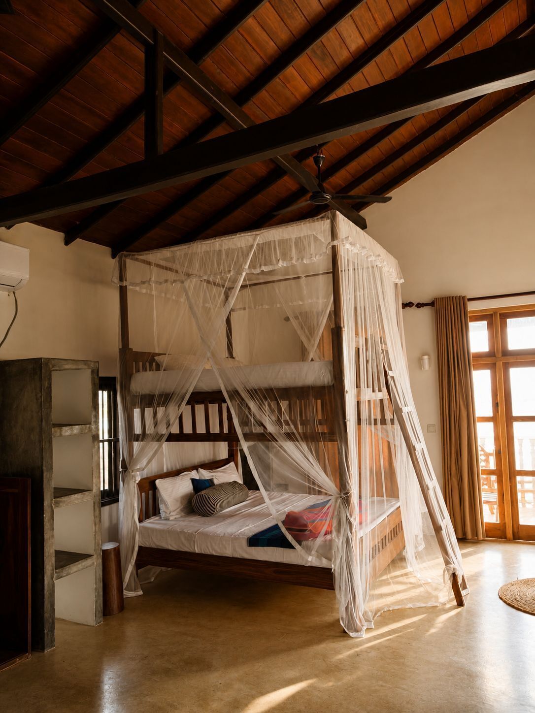 Ein vierstimmiges Bett mit Baldachin, Holzbalken an der Decke und ein großes Fenster mit Vorhängen.