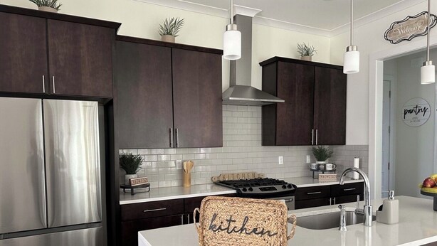 A modern kitchen with dark cabinets, stainless steel appliances, and a central island. - LSU BOUND! We are minutes from everything! (Baton Rouge)