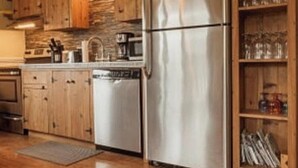 A kitchen with wooden cabinets, a stainless steel refrigerator, and a built-in wine rack.