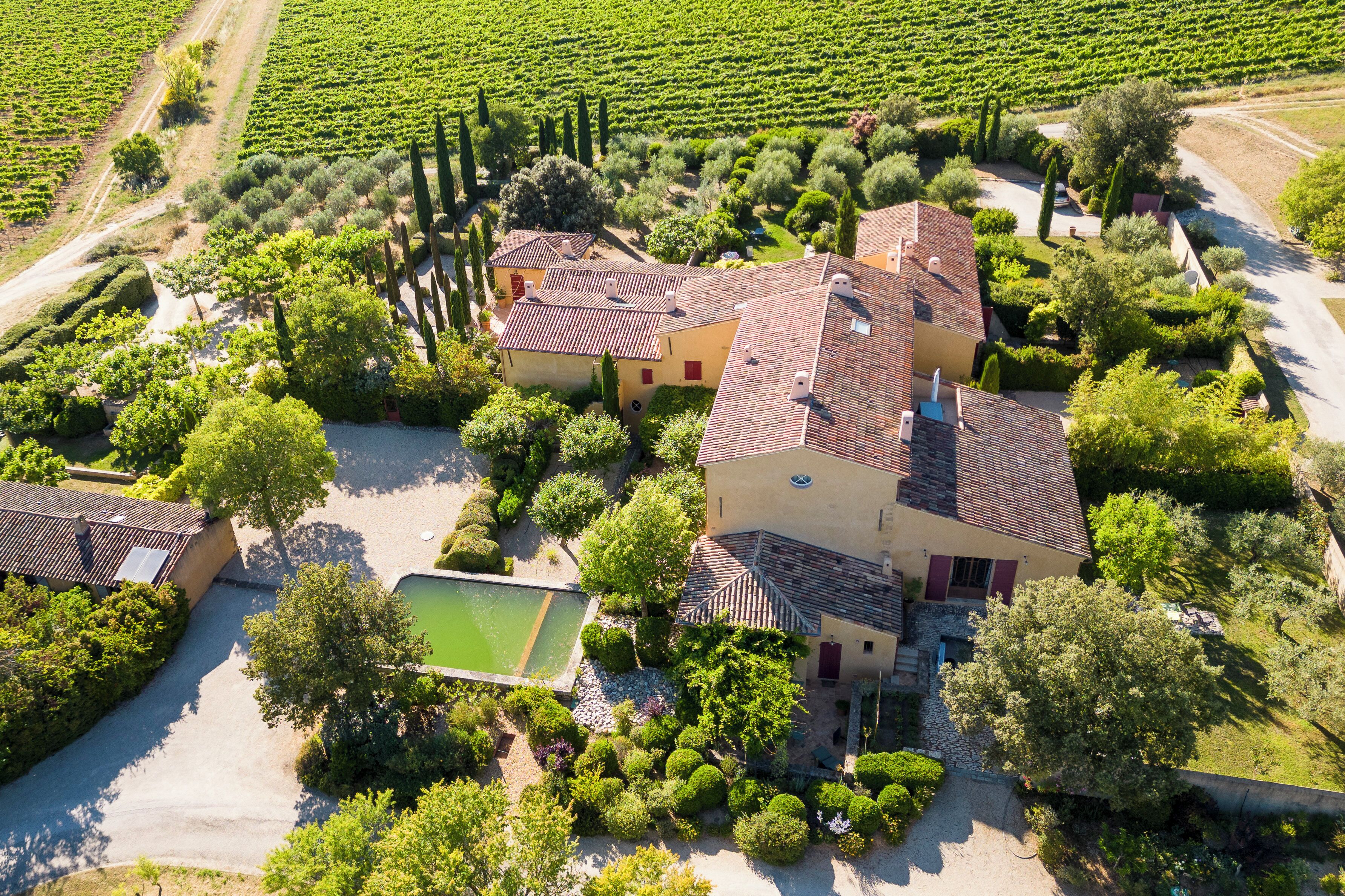 A large estate with multiple buildings, a swimming pool, and extensive greenery.