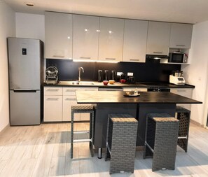 Eine moderne Küche mit Kühlschrank, Mikrowelle und Kaffeemaschine.