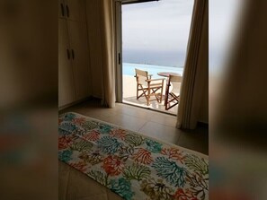 A room with a view of the sea, a wooden table with chairs, and a floral-patterned rug. - Private Villa with Large Infinity Pool & Stunning Ionian Views (Skala)