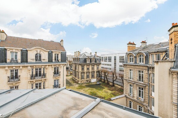 A view of a courtyard surrounded by historic buildings with balconies and a clear sky.