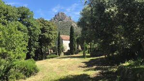 A rural landscape with a building surrounded by trees and a mountain in the background. - Charming house in a magnificent park facing the sea and its sunset (Pigna)