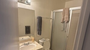 A bathroom with a sink, toilet, and shower. - West LA Wold Cup Hideaway (Los Angeles)