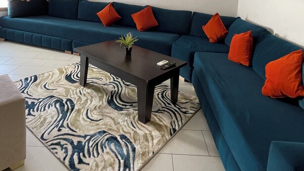Ein modernes Wohnzimmer mit einem Ecksofa, einem Couchtisch und zwei an der Wand hängenden Bildern.