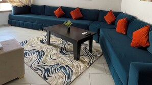 Ein modernes Wohnzimmer mit einer Eckcouch, einem Couchtisch und Kunstwerken an den Wänden.
