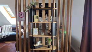 A room with a wooden bookshelf, a clock, and a sign indicating no smoking. - Apartment with high-quality furnishings and underground parking space in Burghausen. (Burghausen)