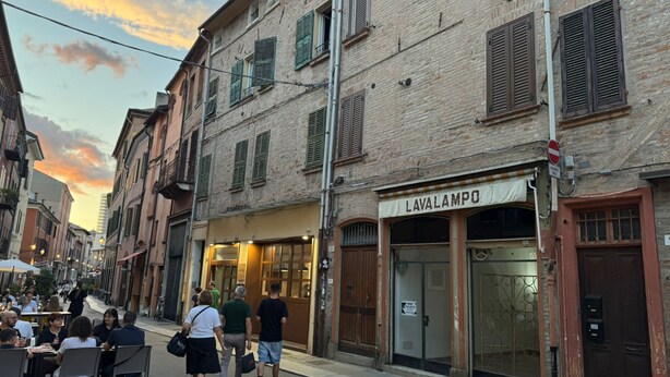 A street with buildings, a restaurant named 'Lavalampo,' and people walking. - Ancient Street - Historic Center (Ferrara)