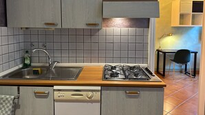 Eine Küche mit Gasherd, Spüle und Schränken.