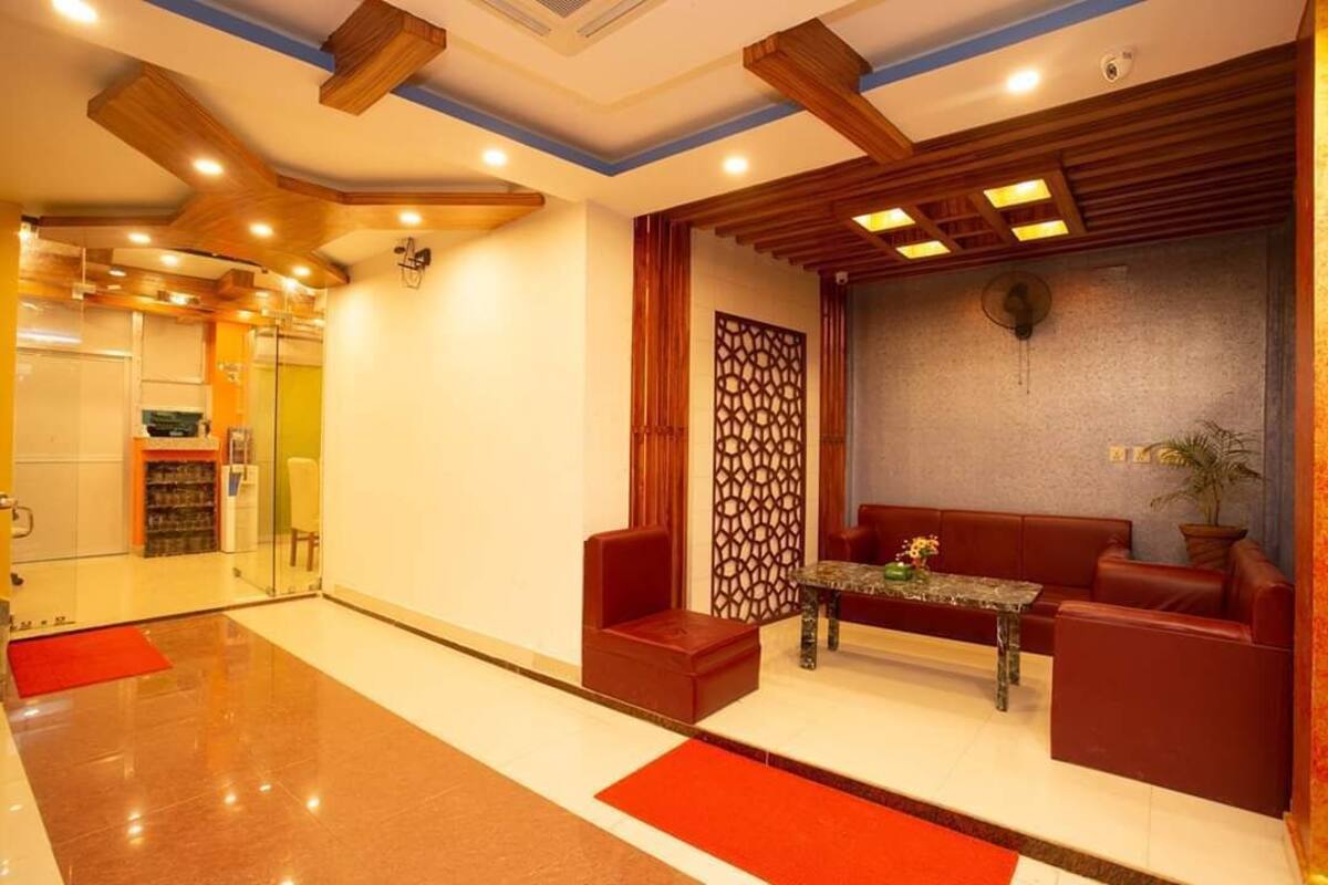 A lobby with a reception desk, seating area, and a glass partition.