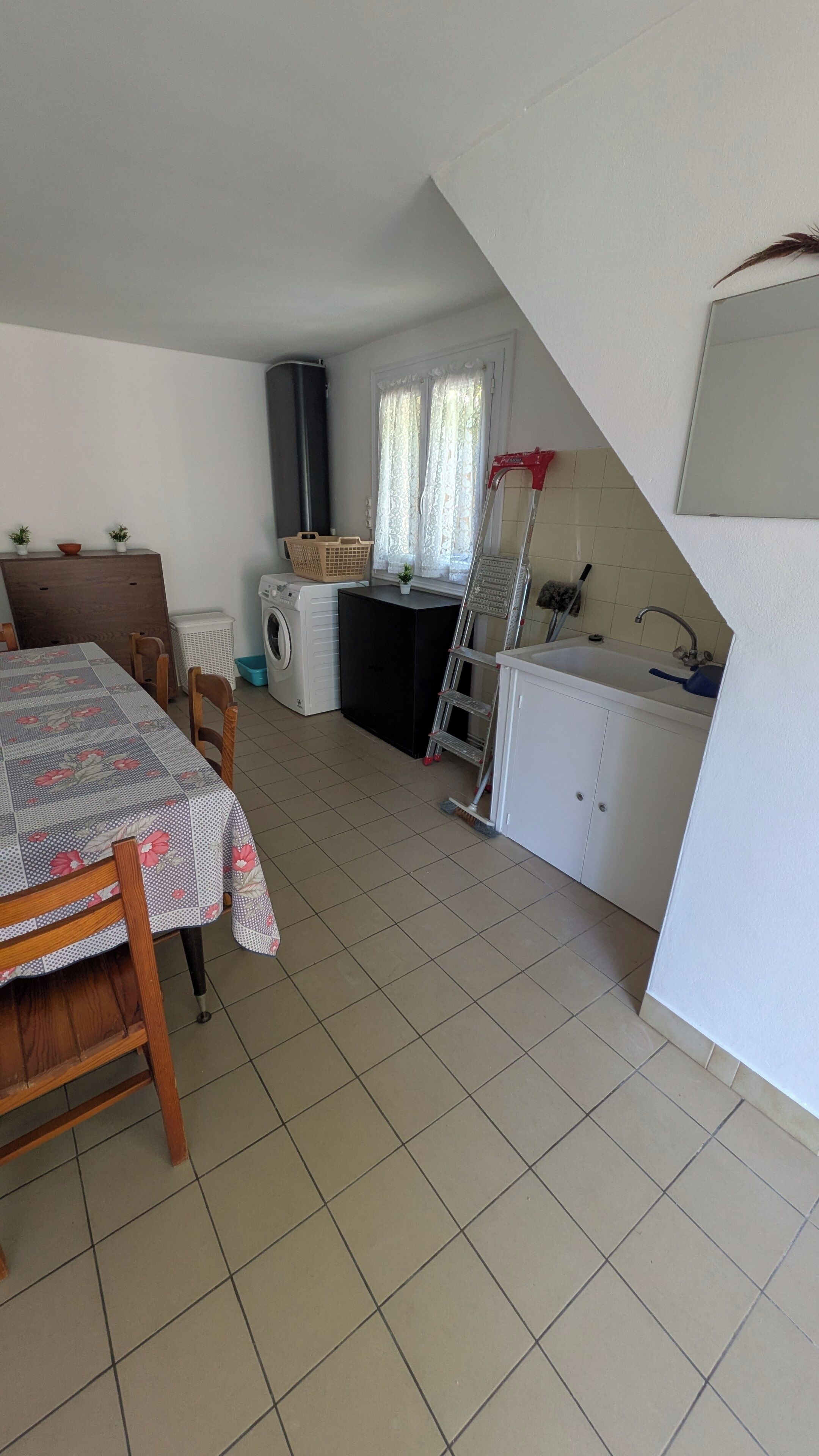 A compact kitchen with a sink, stove, and laundry area.