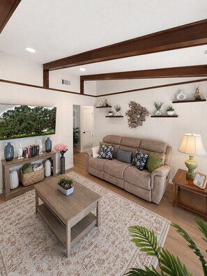Sala de estar com sofá, mesa de centro e objetos decorativos.
