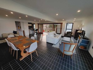 A spacious living area with a dining table, sofas, and a kitchen in the background. - La Corbusière de Pessac (Pessac)
