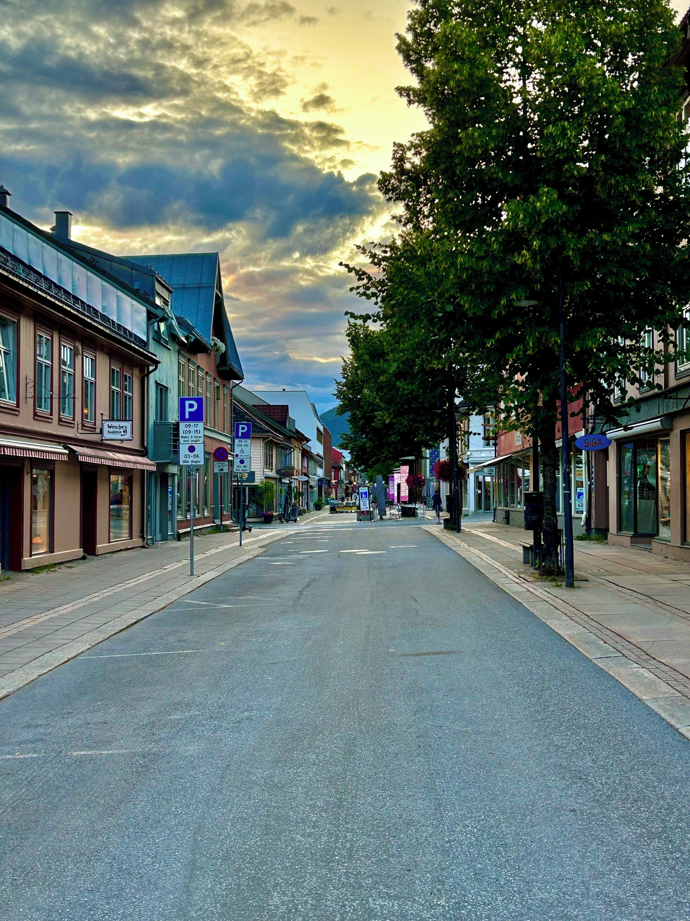 Eine Straße gesäumt von historischen Gebäuden, ein klarer Himmel und ein Fußweg.