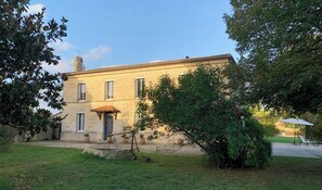 A two-story stone building with a central entrance, surrounded by greenery and a clear sky. - Vacation home between vineyards, estuary and ocean (Saint-André-de-Cubzac)