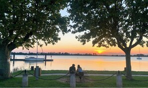 A sunset view from a park bench overlooking a calm lake with boats. - Vacation home between vineyards, estuary and ocean (Saint-André-de-Cubzac)