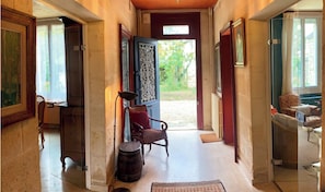 A hallway with a chair, a barrel, and a rug. - Vacation home between vineyards, estuary and ocean (Saint-André-de-Cubzac)