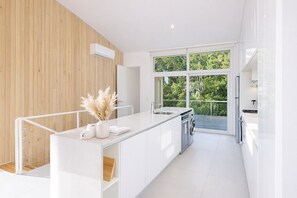 A modern kitchen with a large window, a built-in oven, and a washing machine. - Signature Lake View Luxury Residences M32 (San Carlos de Bariloche)
