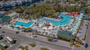 An aerial view of a resort with multiple swimming pools, a water park, and a parking area. - Steps to Sand, Ocean Views, Water Park & Golf Cart (Myrtle Beach)