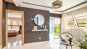 A modern bedroom with a bed, a mirror, a round table, and a chair.