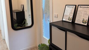 A hallway with a mirror, a door with frosted glass, and a black console with welcome signs. - Lake house 40 minutes from Peschiera Del Garda, comfortably sleeps up to 4 people. (Mantova)