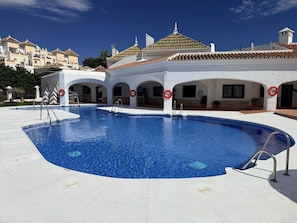 A swimming pool with a white building in the background. - Capistrano Playa Luxe by the Sea - Nerja (Nerja)