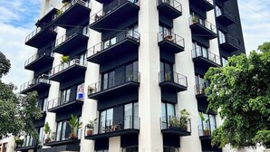 Un edificio a più piani con balconi, ampie finestre e un'area pavimentata.
