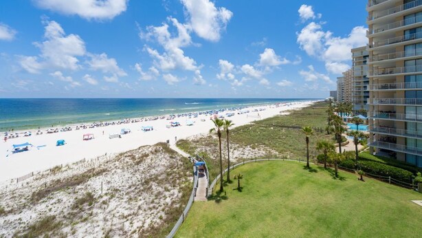 A beach view with a hotel, sandy beach, and ocean. - Summer House Condo 503B (Orange Beach)
